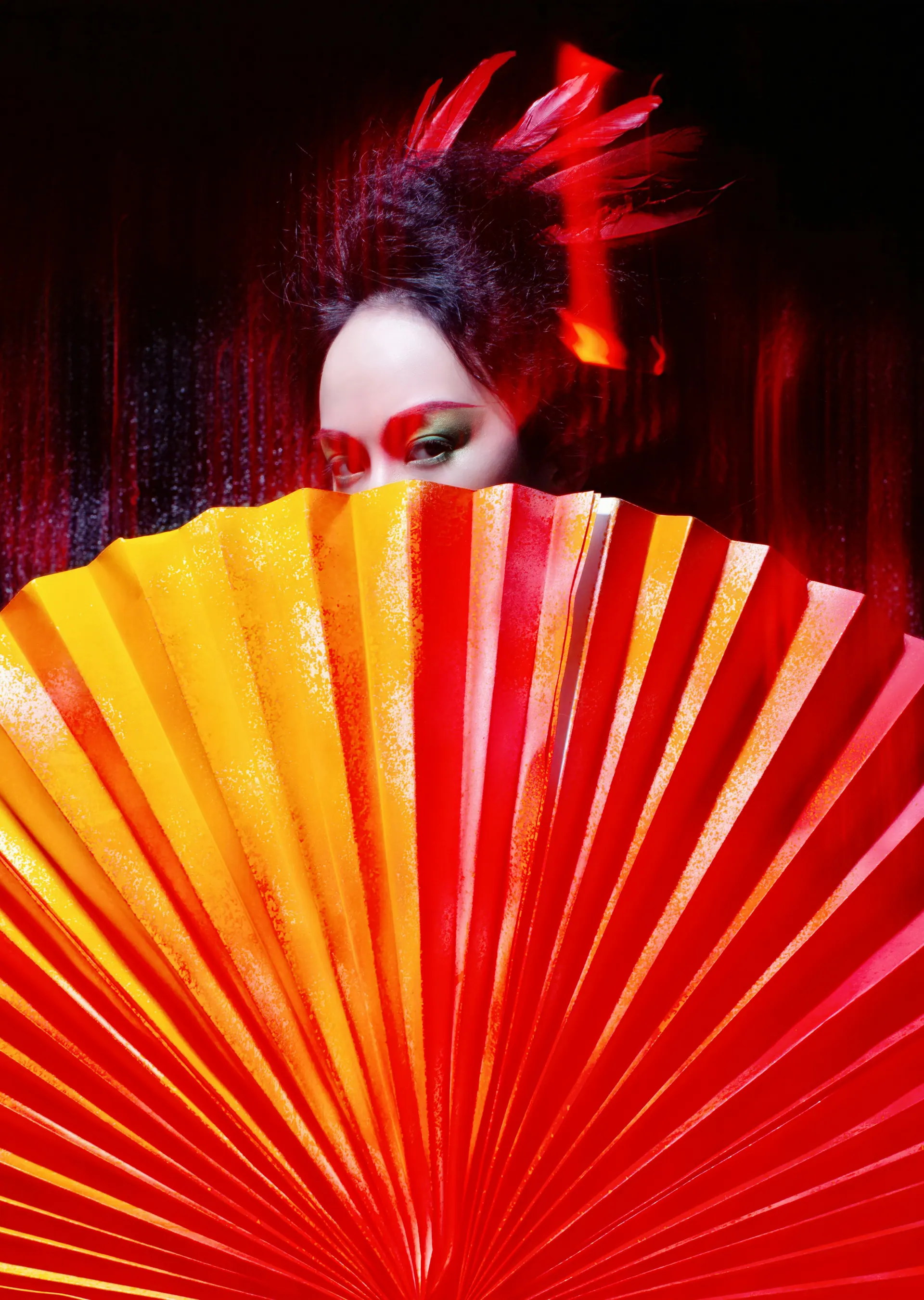 Red paper fan against a dark backdrop