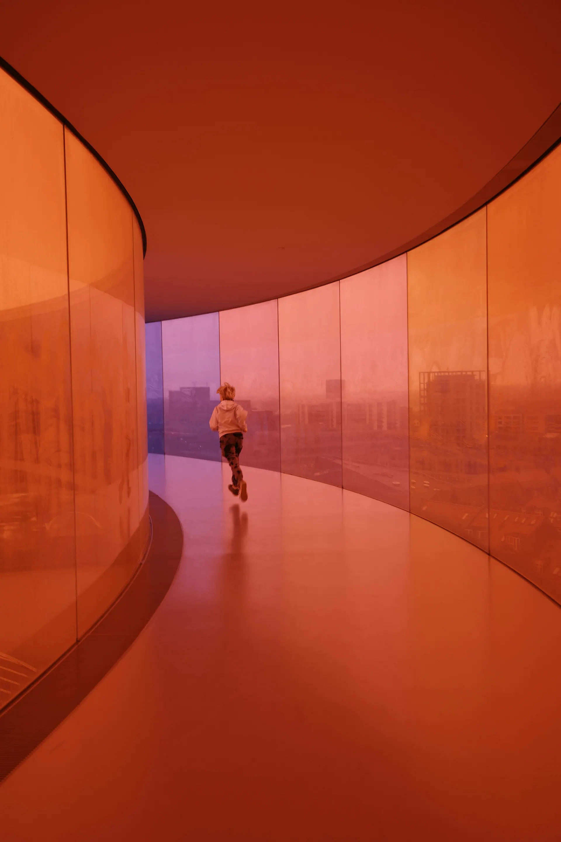 Runner moving through a curved, sunlit corridor